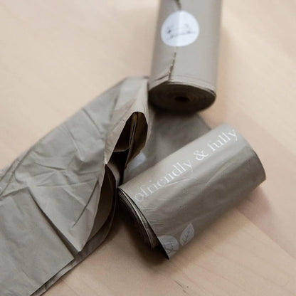 Two rolls of gray paper with 'friendly & fully' branding on a beige surface.